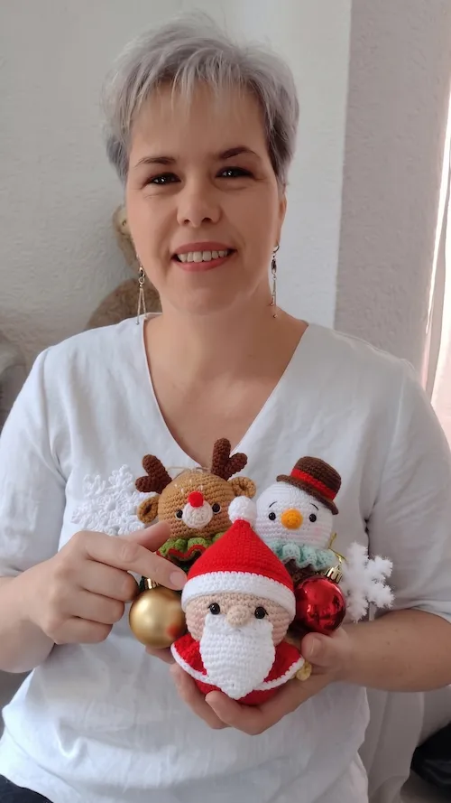 Profe Anita, maestra crochetera, sosteniendo esferas navideñas tejidas